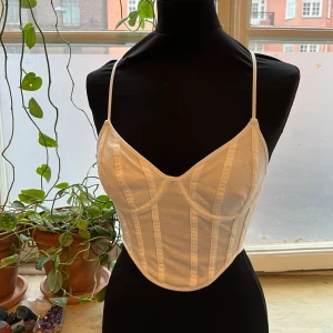 Vintage korsett-topp - En klarvit korsett topp med dragkedja bak. Helt oanvänd från märket bershka. Dockan på bilden är en strl S. Så 