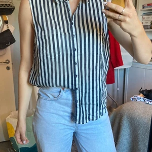 Ärmlös skjorta - Blåvitrandig ärmlös skjorta från gina tricot. 