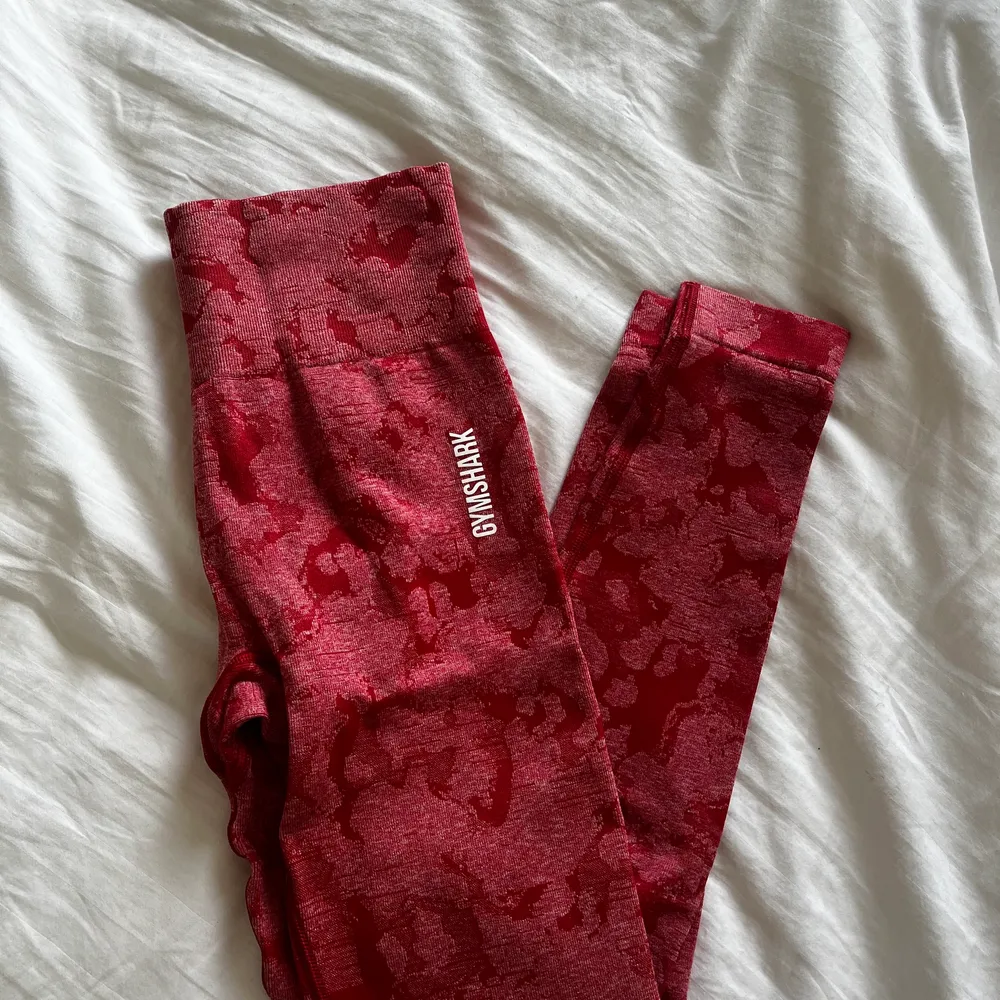 Gymshark tights i röd färg med kamouflage-mönster, de är aldrig använda och helt nya. Lappen sitter inte kvar däremot. Storlek small. Köparen står för frakt!. Jeans & Byxor.