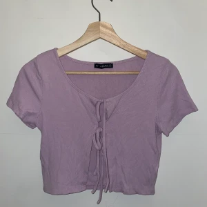 Knyttröja - Lila tröja från Zaful med två knyten på framsidan i ett mjukt ribbat material. Storlek 38 men passar nog allt från 34-38 (XS-M) då den är stretchig och man kan använda den både som kofta och som tröja.