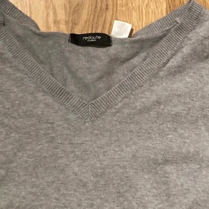 Grå långärmad tröja  - Vanlig långärmad grå tröja som har en v-ringning, den är fin stickad.
