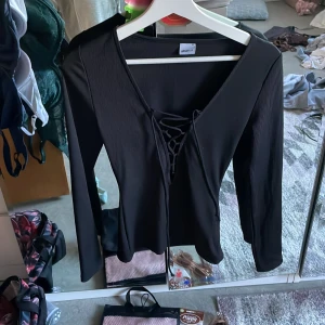 Långärmad tröja med knytning vid bröstet  - En långärmad tröja med knytning vid brösten knappt använd