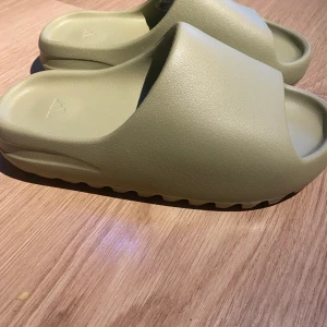 Yeezy slide resin - Helt nya yeezy slide resin som köptes från confirmed. Kvittot Finns kvar. Meetup i Stockholm eller frakt. STORLEK 43