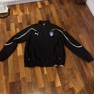 Puma jacka/kofta storlek M - En jättefin Puma-jacka /kofta som passar nästan alla årstider och passar båda könen.  Köpte den från Italien, har inte använt den på länge bara några få gånger.  Kan träffas i Täby, annars levererar jag det via post nord. Jackan kostar 200:- med frakt.