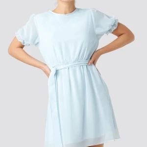 Blå kort klänning  - Blå oanvänd sommarklänning. Köpt från NAKD, strlk 34. Säljer pga använder aldrig men den är väldigt fin. Färgen är precis som på första bilden. Väldigt ljusblå. Köparen står för frakt 📦 