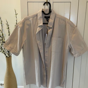 Beige skjorta  - Helt oanvänd beige skjorta med bröstficka och knappar 