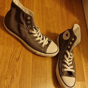 Converseskor - Gråa/mörkgråa (höga) converse, oanvända. Conversemärket är på insidan av skorna. Storlek: Men 7. Women 9. Uk 7. Euro 40. Cm 25,5