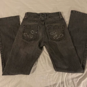 Lågmidjade jeans - Säljer detta par utsvängda, lågmidjade jeans från Lindex. Supercoola, men tyvärr för små för mig. De är i okej skick. Saknar några stenar och är lite slitna längst ner på byxbenen (kan skicka bild), men fina ändå. Kontakta mig om du har frågor 🥰