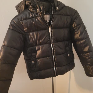 Kids only dunjacka - I fint skick, inte repor eller märken. Svart glansigt material. Stor favorit! Kan användas för höst/vår eller vinter med mellanlager under.
