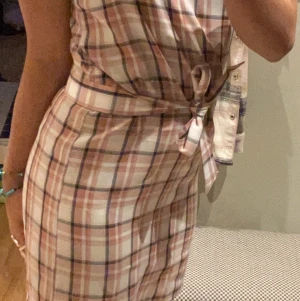 Klänning - Rosa rutig klänning, med tillhörande ”skärp” dragkedja på sidan och reglerbara axelband 