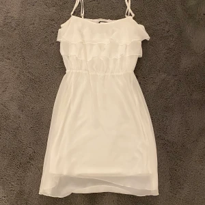 Klänning  - Vit klänning med volanger 