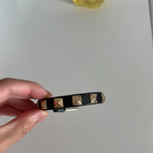 Valentino armband  - Svart och guld. Armband med nitar, jättelikt valentino, men detta är från ett annat märke Dark (inte den från Shein som ser jättebilligt ut).   Alexander mcqueen, ugg, moncler jacka, Zadig, dior, new balance 550, valentino bag, ATP skickas i kuvert, 45kr