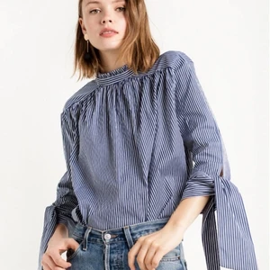 Skjorta - Blå-vitrandig skjorta med fina detaljer, Knappar längst ryggen och manchetter som knyts. Gör att hämtas upp i Malmö eller skickas med post :)