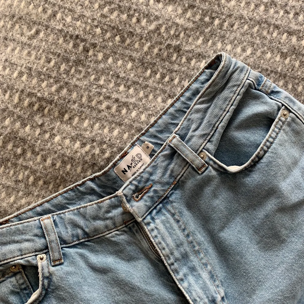 Blå jeans från Na-kd med slits nedtill. Sparsamt använda pga fel storlek. Storlek 38. Kan skickas.. Jeans & Byxor.