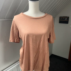 Basic Tee - En basic T-shirt i en rosa-beige färg från Ginatricot i storlek M.