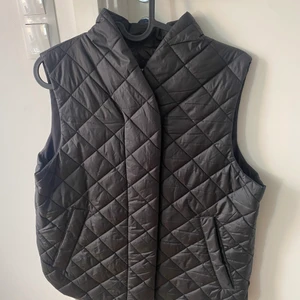 QUILTAD VÄST IFRÅN LINDEX - QUILTAD SVARTVÄST IFRÅN LINDEX STORLEK S. NYPRIS 399:- 100% polyester. Endast använd vid ett tillfälle.