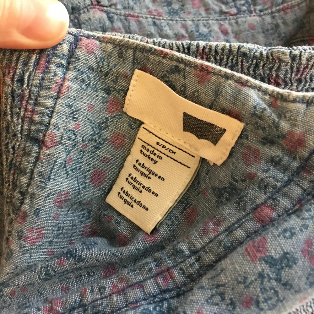 Kort korsett i jeans med elastisk del på baksidan, blommig mönster. Neckholder band. . Toppar.