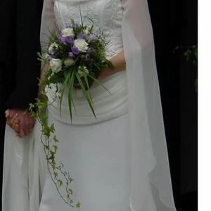 Angelbride den ende - Brudklänning - Brudklänningen - den enda i sitt slag -designad av "Angelbride" är i matt duschess med draperingar, öppna trumpetärmar och släp av chiffong.  Strl. uppskattningsvis ca 36/38. Mötas vid köp eller sänds vid behov. Köparen står för ev. frakt. Pris förhandlingsbart.