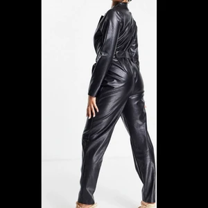 Faux leather jumpsuit - Jag säljer min svarta jumpsuit i fuskläder. Köpt för 609kr säljer för 300. Aldrig använd med prislappen kvar.