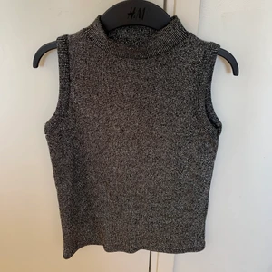 Glittrig topp - En silverglittrig festtopp! Polokrage och ärmlös och sitter väldigt snyggt på en 👍 Har tyvärr aldrig kommit till användning hos mig!