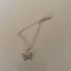 Silvrigt armband med en fjärilsberlock  - Detta silvriga armbandet köpte jag för ett tag sedan men vet att jag inte kmr att använda så att nu säljer jag det. Det är silvrigt med en fjärilsberlock på.