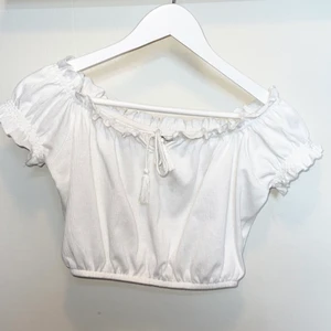 Kroppad blus från Newyorker i S - En fin kroppas blus i storlek S från Newyorker. Vit och har små toffsar på snörena. Super söt🤍 