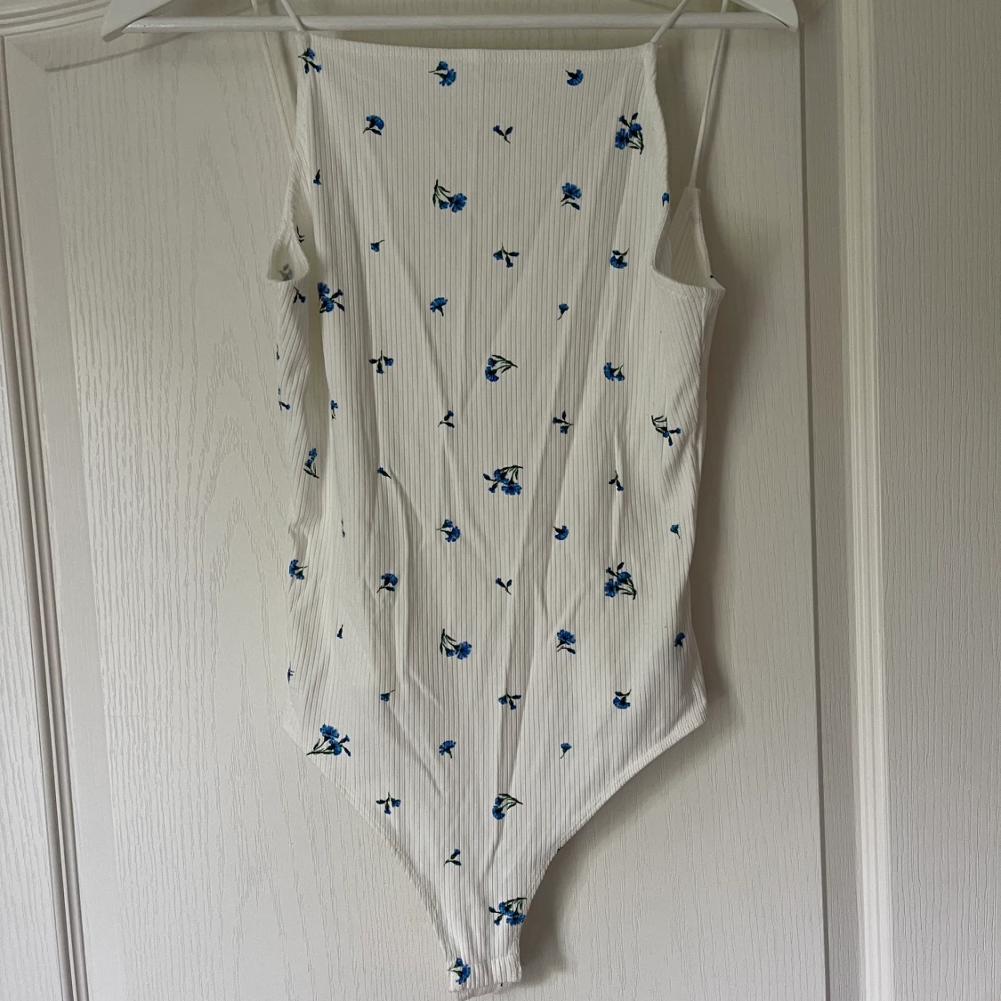 Vit body med blåa blommor 