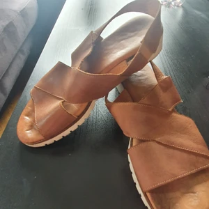 Använda Dasia-skor, 37 - Fortfarande sköna, storlek 37. Använda, i befintligt skick. Brun läderimitation, skönt att ha hemma som tofflor eller ute på småpromenader.