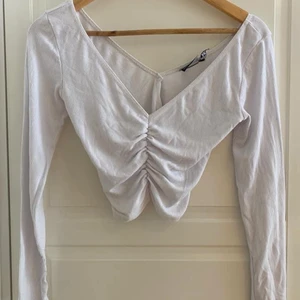 Asos topp - Vit ribbad rynkad topp från Asos i storlek xs men den passar xs/s pga mycket stretch. Skick: använt skick och är lite ytluddig och någon noppa men det syns knapp när man har på sig den. Finns en bild där man kan se. 