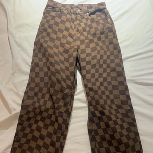 Bruna rutiga jeans  - Bruna rutiga jeans med en liten slits i slutet av byxorna, använts 1 gång