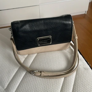 Marc by Marc Jacobs väska - Det här är en marc jacobs väska som har en ficka inne och ute  Den är röd inne och svart beige ute  Axelremmen har gått av men har kunats sättas tillbaka    Pris kan diskuteras!