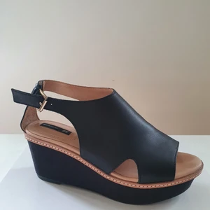 Platåsandaler i läder strl 39 H&M trend Premium  - Platåsandaler i äkta läder strl 39. Klackhöjd ca 7 cm. Platå i fram ca 4cm hög. Innersula också läder. Platån klädd i svart textil. Använda endast 1 gång, som nya. Märke H&M premium Trend 