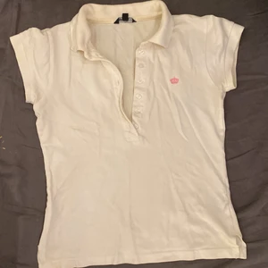 polotröja  - Fin vit polotröja från gina tricot i storlek xs. Den har en liten rosa krona på sidan 