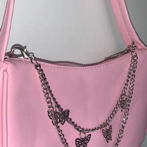 Säljer denna väska med kedja med fjärilar som går att ta av och sätta på annars en söt liten rosa väska köpt från SHEIN 