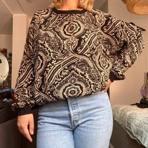 Mönstrad långärmad topp - Mönstrad långärmad topp med mudddetaljer. Snygg och aningen pösig! Sparsamt använd 