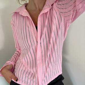 Rosa randig skjorta, lite genomskinlig mellan ränderna, köpt secondhand! Oanvänd!