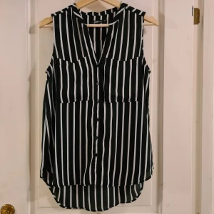 Blus Gina Tricot 34 - Svartvit blus med knappar från Gina Tricot i storlek 34. Sparsamt använd i fint skick. Hittar ingenting att anmärka på.  Frakt tillkommer på 39 kr 🌞