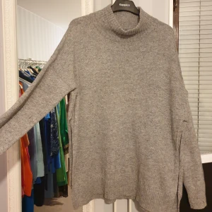 Stickad tröja med ull  - Stickade tröja köpt på MQ, för cirka 500-600. Den är helt oanvänd, så säljer nu då det inte rikigt var min stil.  Slits i sidorna. 50 % ull, så den är varm.