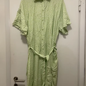 Grön klänning strl L - Aldrig använd.  Grön, blommig klänning från Monki. Avslappnad passform.  Säljer pga felköp.