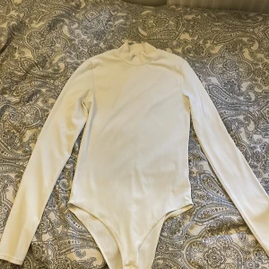 En body suit  - Jag tror de kalla för en body suit som är i väggen kräm vit och i storlek S. Endast använd en gång och i my let bra skick.