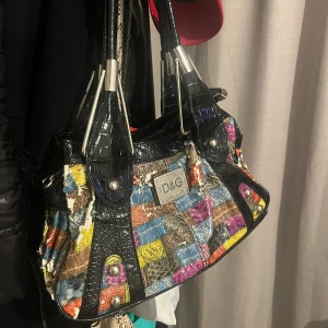 Dolce & Gabbana väska  - Ur snygg D&G väska med vibranta färger som du lätt kan ha över axeln. Dock håller materialet på att flagna, därmed de billiga priset:) (skickas ej)