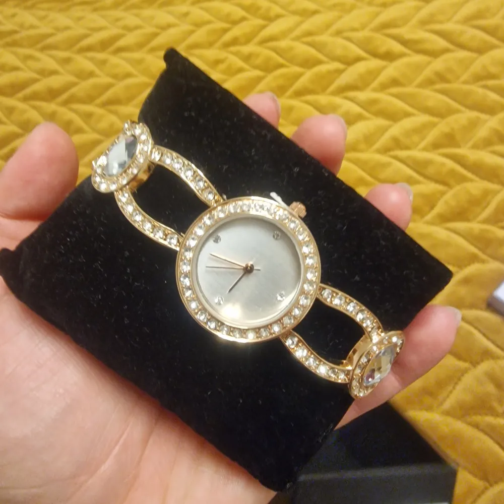 En helt nytt och fint damklocka med stenar på, Inne från det är mother of pearl med stenar. Plus också klistermärken är fortförande på. pasar så bra som en present eller kanske till dig själv,snart är julen ✨️. Asusteet.