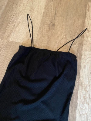 Svart body  - Tight body med spaghetti-straps. Helt oanvänd!