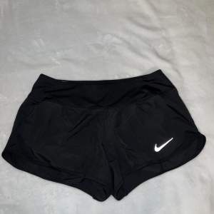 Korta och tunna träningsshorts från Nike i storlek S. Sitter tight men lösare runt benen. Använda en eller två gånger, alltså fortfarande i gott skick. Stretchiga i midjan. 