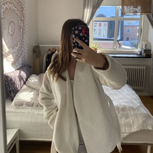 Teddykappa - Vit teddykappa som är väldigt mysig o har ett skärp som man kan knyta runt midjan🌦från Nelly.com och aldrig använd! 