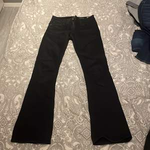 Lågmidjde utsvängda svarta jeans. Storlek 26 midja 31 längd. Ungefär xs/s. Bra skick. 