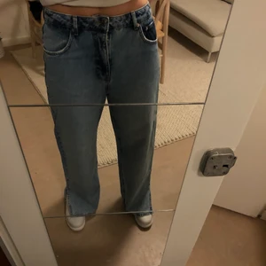 Nakd straightleg jeans med slits - Raka jeans från nakd med slit längst ned. Köpta för 3 månader sen men aldrig använda pga köpte för stor storlek. Högmidjade och knappar för att stänga. Långa i benen är 177 cm. 