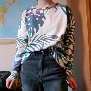 Mönstrad sweatshirt - Fin sweatshirt med vit bakgrund och bladmönster i diverse färger.