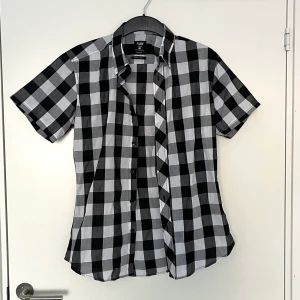 Kortärmad skjorta - Rutig skjorta i svartvit! Plagget är helt nytt och har aldrig använts! Ingen retur. Alla plagg som säljs tvättas noga innan leverans! Det är bara att skriva om du har några frågor! <3