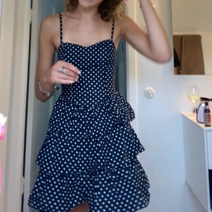 Klänning  - Marinblå och vitprickig klänning som går att ha med band, utan band (off shoulder) och som kjol!! Storlek 34 (passar mig 175 och xs/s), resår på halva överdelen, skriv för fler bilder ! 